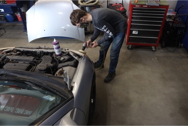 student working on car